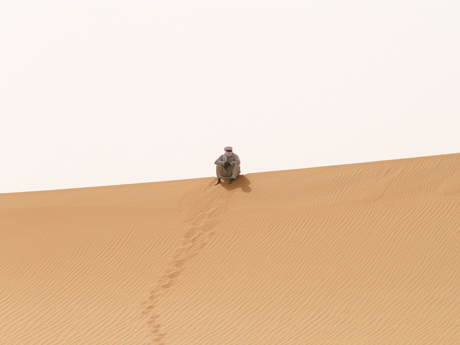 Ramlat Assayef - Tuareg sitting on the sand dunes